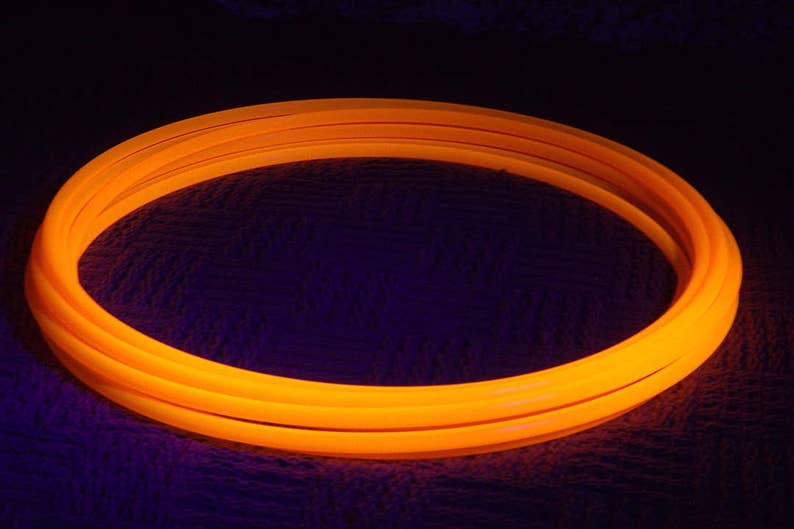 May include: A bright orange glow stick hoop, a popular toy for kids and adults. The hoop is made of flexible plastic and is designed to be safe for play.