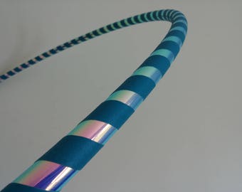 May include: A blue and iridescent hoop with a striped pattern. The hoop is made of plastic and is flexible.