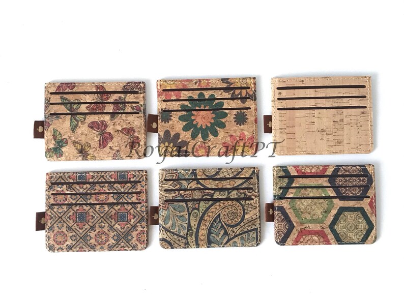 May include: Six different cork card holders with various patterns. The card holders are brown with different colored patterns including butterflies, flowers, paisley, and geometric designs.