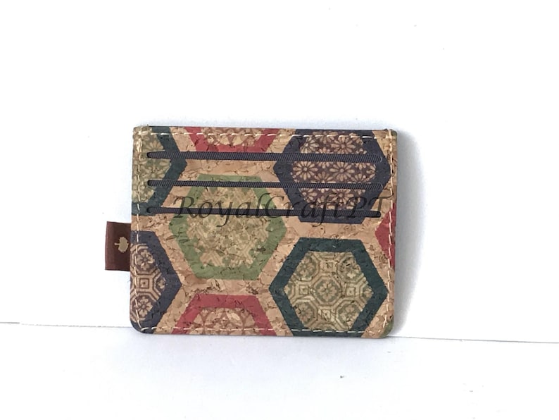 May include: A cork wallet with a geometric pattern in shades of brown, green, red, and blue. The wallet has six card slots and a small flap with a leaf design.