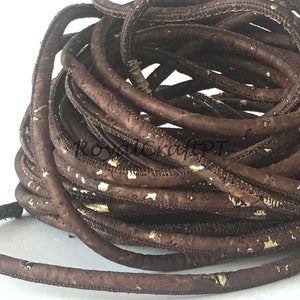 Pu&ograve; includere: Un cordoncino di sughero marrone con macchie dorate. Il cordoncino &egrave; arrotolato ed &egrave; pronto per essere utilizzato per progetti di artigianato.