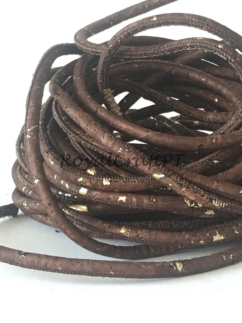 Pu&ograve; includere: Un cordoncino di sughero marrone con macchie dorate. Il cordoncino &egrave; arrotolato ed &egrave; pronto per essere utilizzato per progetti di artigianato.