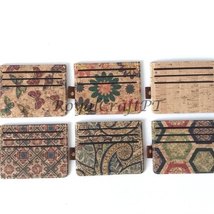 May include: Six different cork card holders with various colorful patterns. The patterns include butterflies, flowers, paisley, geometric designs, and a honeycomb pattern.