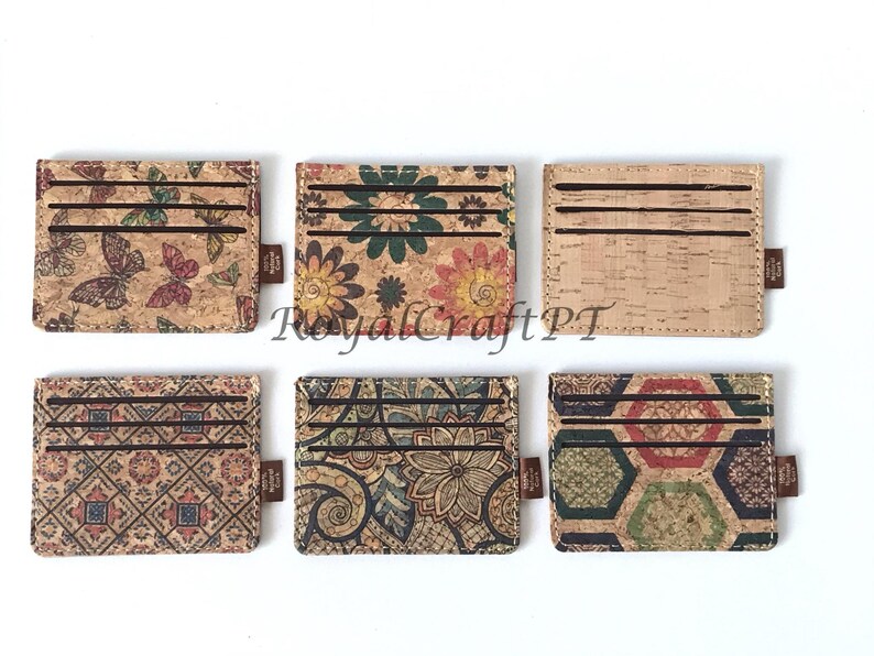 May include: Six cork card holders with different patterns. The patterns include butterflies, flowers, geometric designs, and paisley. The card holders are all the same size and shape.
