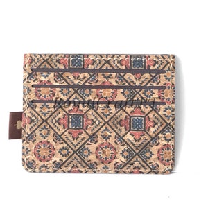 May include: A brown cork wallet with a patterned design featuring red, blue, and white geometric shapes. The wallet has multiple card slots and a brown leather strap.