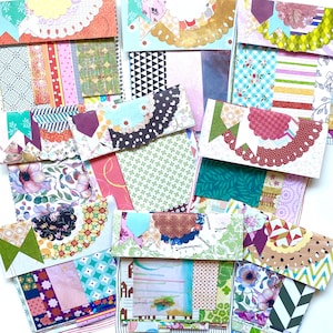 May include: A selection of handmade paper wallets with diverse, colourful patterns. Each wallet showcases a unique mix of fabrics, including floral, geometric, and abstract designs. The wallets have scalloped edges and decorative accents.