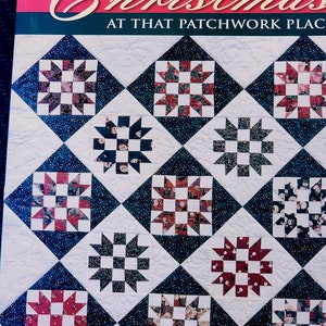 May include: A book titled "Christmas at That Patchwork Place" with a cover featuring a quilt design of red, green, and white squares arranged in a diamond pattern.