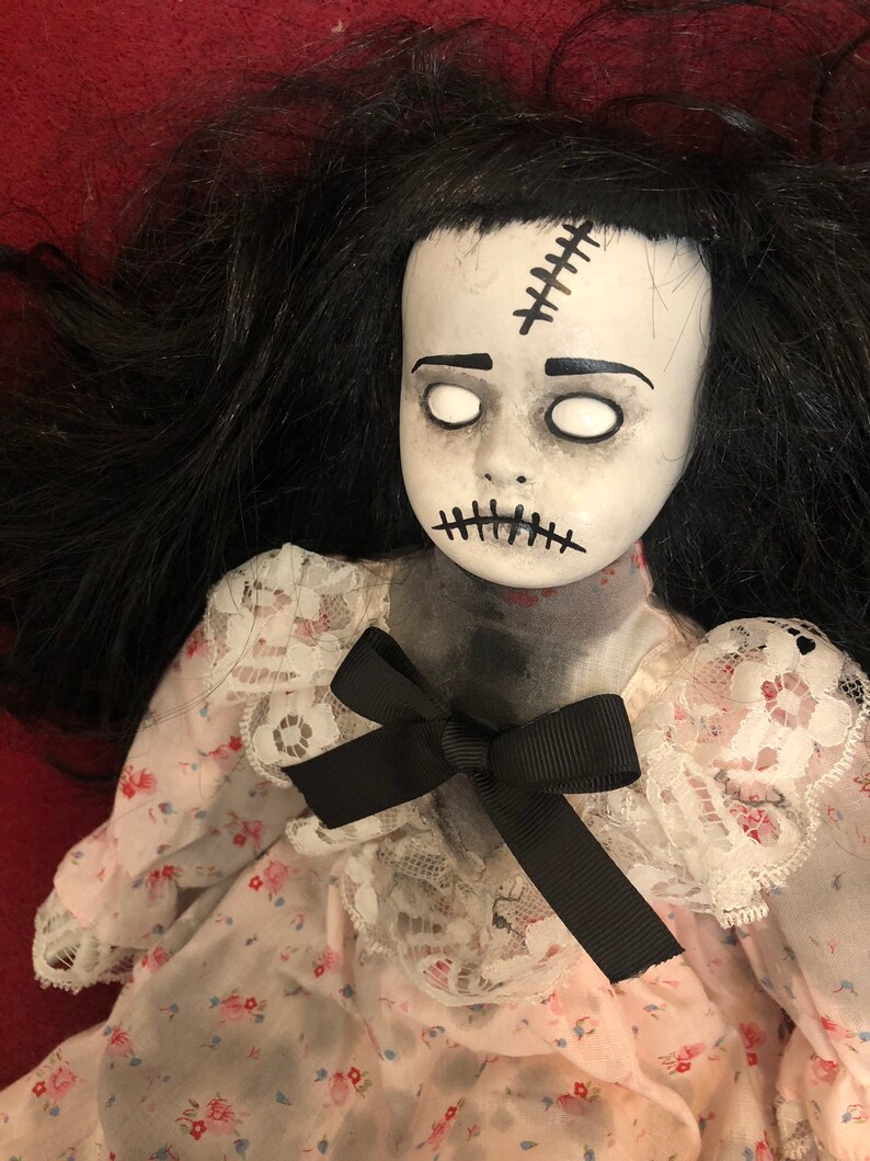 creepy girl with black hair and doll