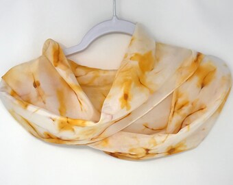 May include: A white silk scarf with a yellow and orange tie-dye pattern.