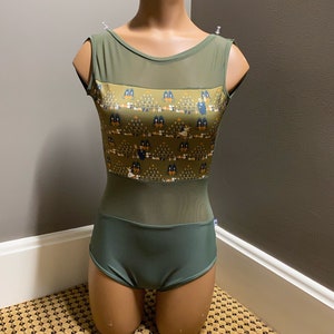 Op de afbeelding: Een groene maillot met een mesh-paneel en een bedrukt ontwerp met uilen en bomen. De maillot heeft een ronde hals en is mouwloos.