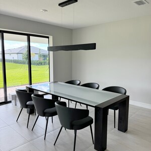 Side view of the linear pendant light made from solid wood, featuring clean geometric lines and a natural oak tone.
