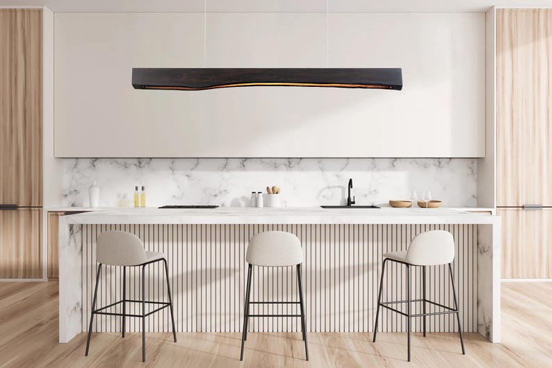 Linear wooden pendant light turned on in a modern interior, casting warm ambient lighting that creates a cozy atmosphere in a dining area.