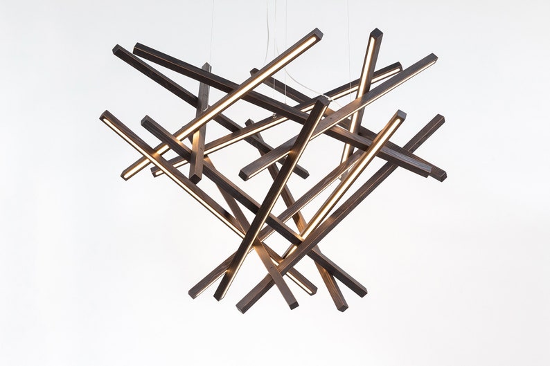Close-up of the wooden chandelier’s faceted diamond geometry and natural wood grain. Handcrafted with precision for a bold architectural look.