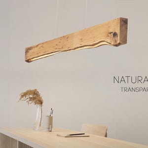 Close-up view of the natural wood grain on the linear pendant light. Warm oak with a matte finish in a clean Japandi aesthetic.