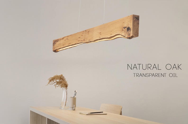 Close-up view of the natural wood grain on the linear pendant light. Warm oak with a matte finish in a clean Japandi aesthetic.