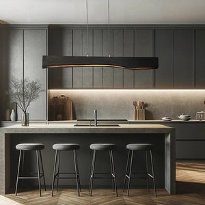 Minimalist wooden pendant light in Japandi style installed above a kitchen island. Sleek, modern design with natural materials