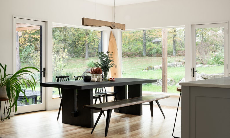 Modern Japandi interior featuring a wooden linear pendant light, natural textures, neutral tones, and clean Scandinavian-Japanese fusion design.