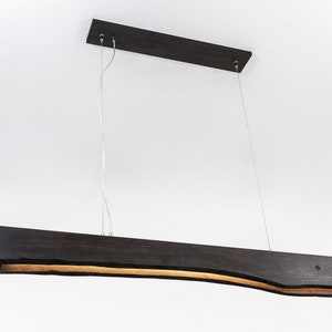 Underside view of the wooden linear pendant light with integrated LED lamps. Functional and minimalist with precise craftsmanship