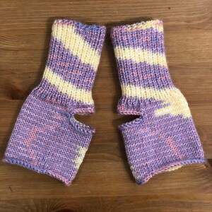 May include: A pair of purple and yellow striped fingerless gloves with a hole for the thumb.