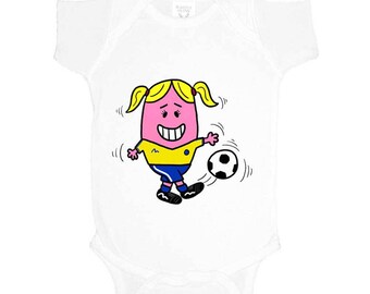May include: White baby bodysuit featuring a cartoon character kicking a soccer ball. The character has a pink face, yellow hair, and is wearing a yellow and blue soccer uniform. The soccer ball is black and white.