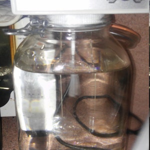 May include: A white SilverGen Colloid Generator with a red and green light indicator. The generator is attached to a clear glass jar with a lid. The jar is filled with a clear liquid.