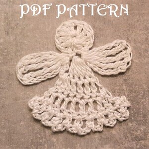 Puede incluir: Adorno de &aacute;ngel blanco tejido a crochet con un dise&ntilde;o detallado. El &aacute;ngel tiene una cabeza redonda con un nudo central y alas hechas de bucles de crochet. El vestido del &aacute;ngel es una campana de crochet.