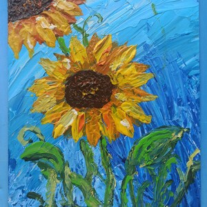 K&ouml;nnte beinhalten: Ein Gem&auml;lde mit zwei Sonnenblumen mit gelben Bl&uuml;tenbl&auml;ttern und braunen Zentren vor blauem Hintergrund. Die Sonnenblumen sind mit dicken, strukturierten Pinselstrichen gemalt.