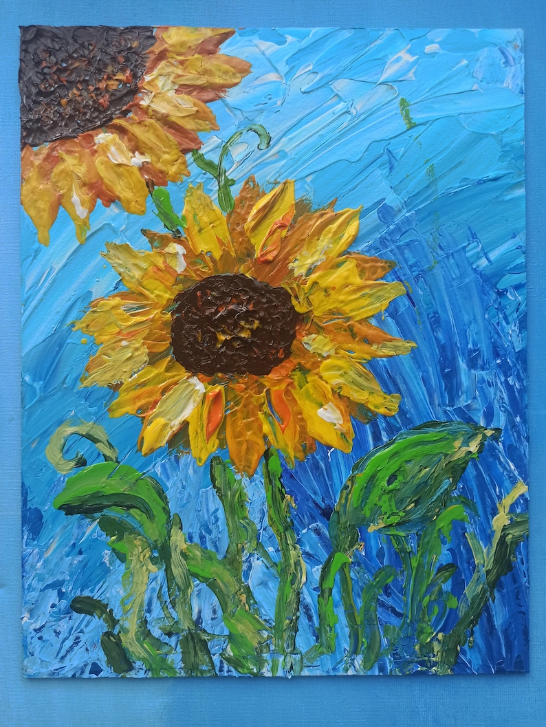 K&ouml;nnte beinhalten: Ein Gem&auml;lde mit zwei Sonnenblumen mit gelben Bl&uuml;tenbl&auml;ttern und braunen Zentren vor blauem Hintergrund. Die Sonnenblumen sind mit dicken, strukturierten Pinselstrichen gemalt.
