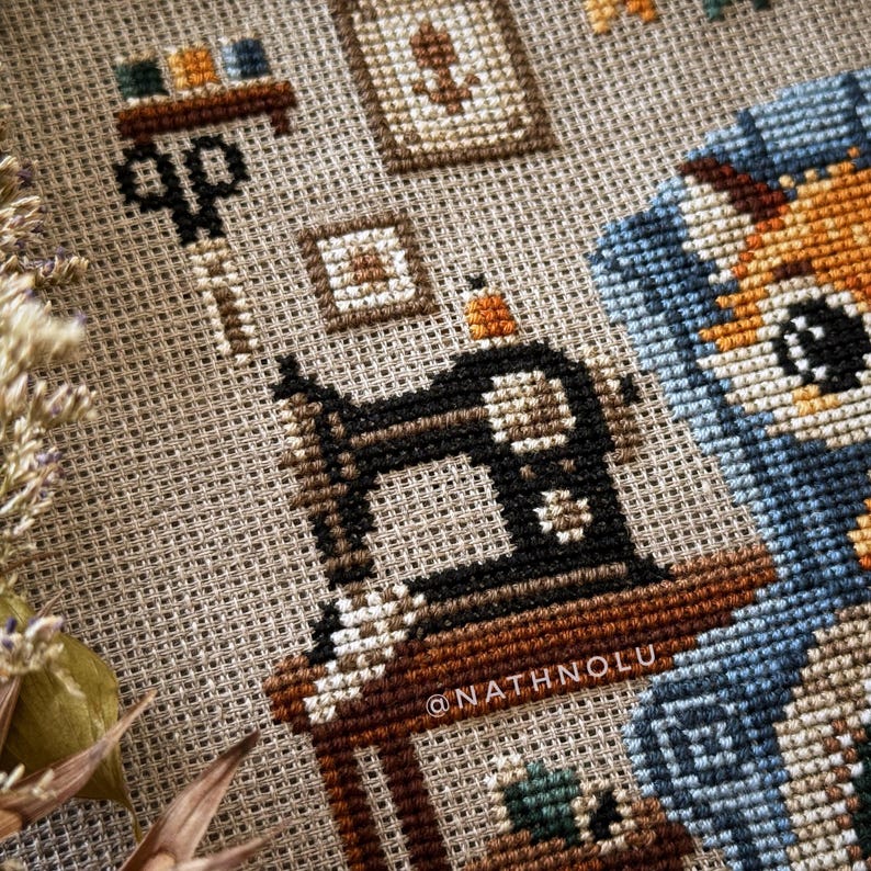 close-up of an embroidery machine and other sewing tools. Scissors, spools of thread, scraps of fabric