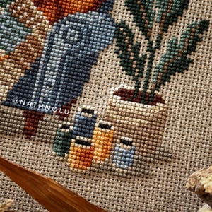 close-up of sewing tools, spools of thread, houseplant in a pot