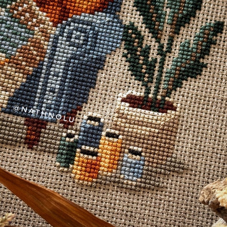 close-up of sewing tools, spools of thread, houseplant in a pot