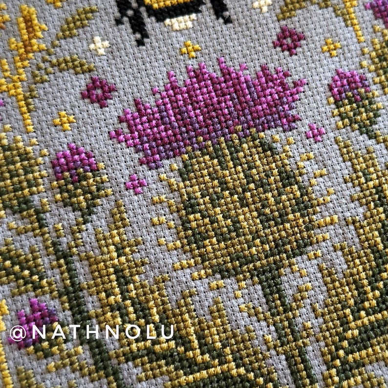 Whimsical insects cross stitch pattern combining a bumblebee, thistle blossoms, and decorative floral symmetry.
