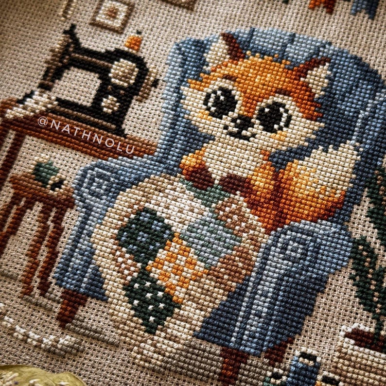 Close-up of the fox’s paws holding the quilt, highlighting detailed stitching and quilt textures.