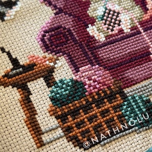 Woodland cross stitch pattern featuring a charming crafter mouse surrounded by crochet projects and yarn skeins