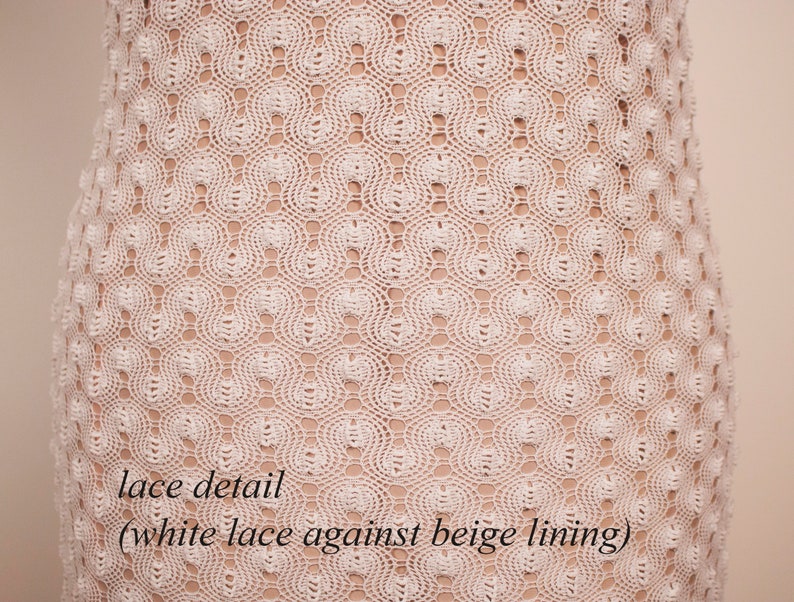 May include: Close-up of a white lace dress with a beige lining. The lace features a repeating pattern of circular designs. The text "lace detail (white lace against beige lining)" is visible at the bottom of the image.