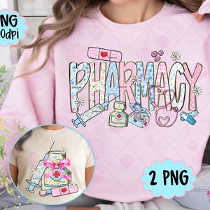 May include: Pink sweatshirt with the word "PHARMACY" in a colorful, patterned design. The design includes a syringe, medicine bottle, first aid kit, stethoscope, and pills. A smaller image of a t-shirt with a similar design is visible.