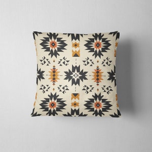 May include: A throw pillow with a geometric pattern in shades of black, orange, and white. The pattern features stars and triangles.
