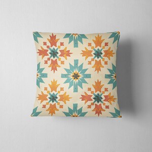 May include: A decorative throw pillow with a geometric pattern featuring teal, orange, and yellow colors on a cream background.