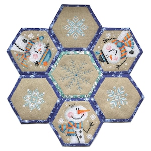 May include: A hexagonal patchwork quilt with a winter theme. Each hexagon features a different design, including snowmen and snowflakes. The quilt is made of beige fabric with blue trim.