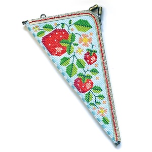 Op de afbeelding: Een driehoekige portemonnee met een lichtblauwe achtergrond en een kruissteekpatroon van rode aardbeien, groene bladeren en kleine roze bloemen. De tas heeft een sierlijk antiek messing frame met een sluiting met twee bolletjes.