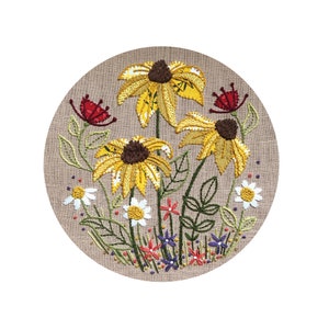 May include: Embroidered design of a circular arrangement of yellow, brown, and red flowers on a beige linen background.