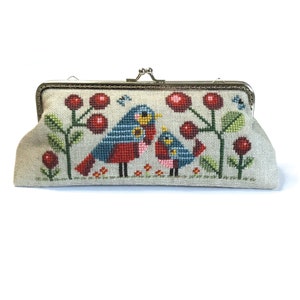May include: A beige fabric clutch purse with a silver metal clasp. The purse is embroidered with two blue birds, red berries, and green leaves.