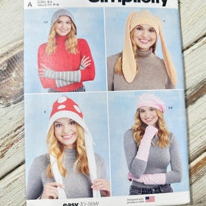 以下が含まれることがあります： SimplicityのソーイングパターンS9871。4種類の帽子と手袋のデザインが特徴です。ビーニー、ウサギの耳の帽子、キノコの帽子、ベレー帽と、お揃いの手袋が含まれています。「easy-to-sew」の文字が見えます。