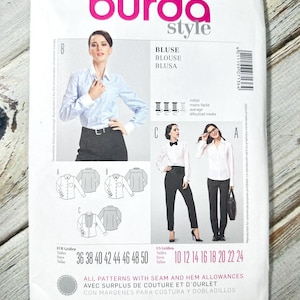 May include: A white and pink Burda Style sewing pattern packet for blouses. The packet features images of blouses, size charts, and the text "BLUSE, BLOUSE, BLUSA". The packet is white with pink and green accents.