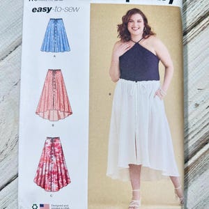 May include: Simplicity sewing pattern S9787, featuring three skirt designs and a halter top. The pattern includes sizes 30W-38W. The cover shows a woman wearing a white skirt and navy halter top. The pattern is easy-to-sew and printed in the USA.