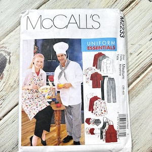 May include: McCall's sewing pattern for Uniform Essentials, featuring a chef and server. The pattern includes various uniform styles, such as aprons, shirts, and trousers. The package is white with blue and red text and images of the finished garments.