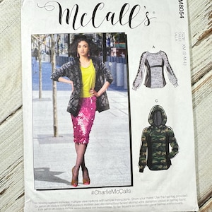 May include: McCall's sewing pattern with multiple view options. The pattern shows a woman in a sequined skirt and patterned jacket. Also shown are a long-sleeved top and a camouflage hoodie. The size is XM (S-M-L).