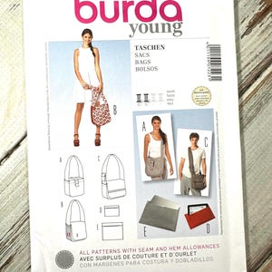 May include: A sewing pattern packet from "burda young" with the number 7223, featuring bag designs. The packet includes illustrations of different bag styles, such as shoulder bags and a tote. The cover displays a woman with a bag and the words "TASCHEN, SACS, BAGS, BOLSOS".