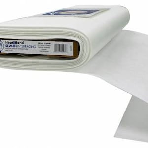 May include: A roll of white HeatnBond Sew-In Interfacing, a fusible fabric used for stabilizing and adding structure to fabric projects. The label on the roll reads "HeatnBond Sew-In Interfacing Soft Washable Non-Woven Fabric 100% Polyester."