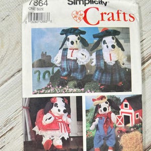 Può includere: Modello di cucito Simplicity Crafts con bambole di cani dalmata in vari outfit. Il modello include le istruzioni per creare le bambole, con immagini che mostrano i prodotti finiti. La confezione è bianca con testo rosso e nero.